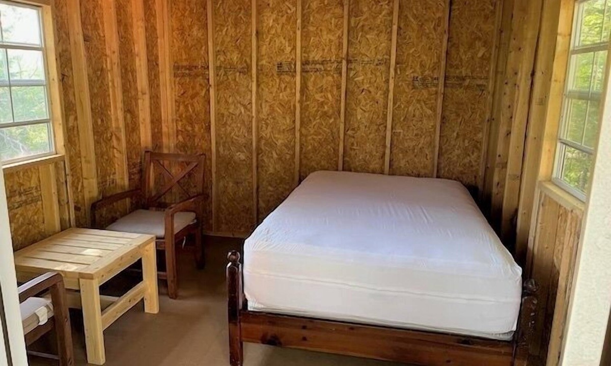 Liscomb Cabin | One Room Cabin with a double bed and small table with two chairs
