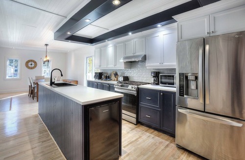 Mont-Tremblant House | Escape to our 100-year-old ancestral home on 23 private acres by Lac Jolicoeur. This lakefront retreat is perfect for large groups of up to 15, offering year-round magic with a private hot tub, stone fireplace, and game room.