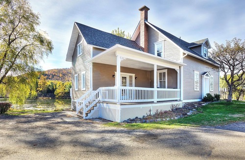 Mont-Tremblant House | Escape to our 100-year-old ancestral home on 23 private acres by Lac Jolicoeur. This lakefront retreat is perfect for large groups of up to 15, offering year-round magic with a private hot tub, stone fireplace, and game room.