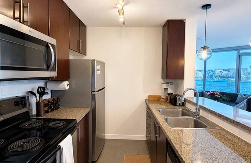 Gastown Apartment | Panoramic floor-to-ceiling windows with water views